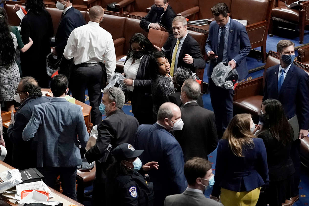 Slide 22 of 76: House of Representatives members leave the floor of the House chamber as protesters try to break into the chamber at the U.S. Capitol on Wednesday, Jan. 6, 2021, in Washington.