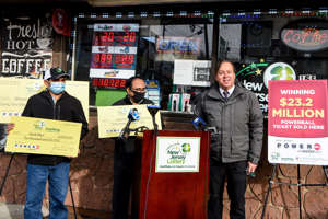 a group of people standing in front of a store: The Quick Mart in Clifton sold not only the $23.2 million Powerball ticket but another $1 million ticket in the same drawing. (From left) Quick Mart owners Rajesh Patel, Mukesh Patel and James Carey, the Executive Director of the New Jersey Lottery, at the Quick Mart on Monday January 25, 2021.