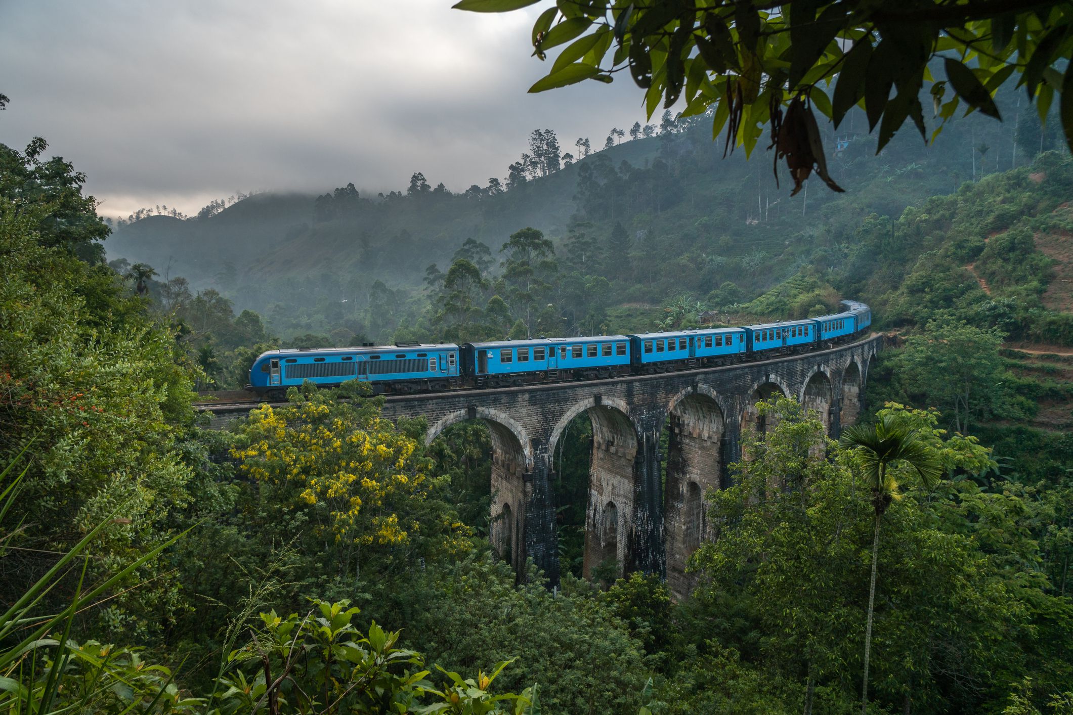 <p>If you’ve seen photos of passengers hanging out of a blue train surrounded by dense, green foliage, you’ve likely seen the Sri Lanka Railways journey from Kandy to Ella in Sri Lanka. </p><p>Although it may not be recommended to hang from objects moving at high speeds, you wouldn’t want to miss the views on this train ride between the central city of Kandy and the small southern town of Ella.</p><p>The ride takes about seven hours and offers views of tea plantations, green hills, bridges and villages. It’s recommended not to book first class tickets for your itinerary, as you won’t have the experience of mingling with the locals and having open windows.</p>