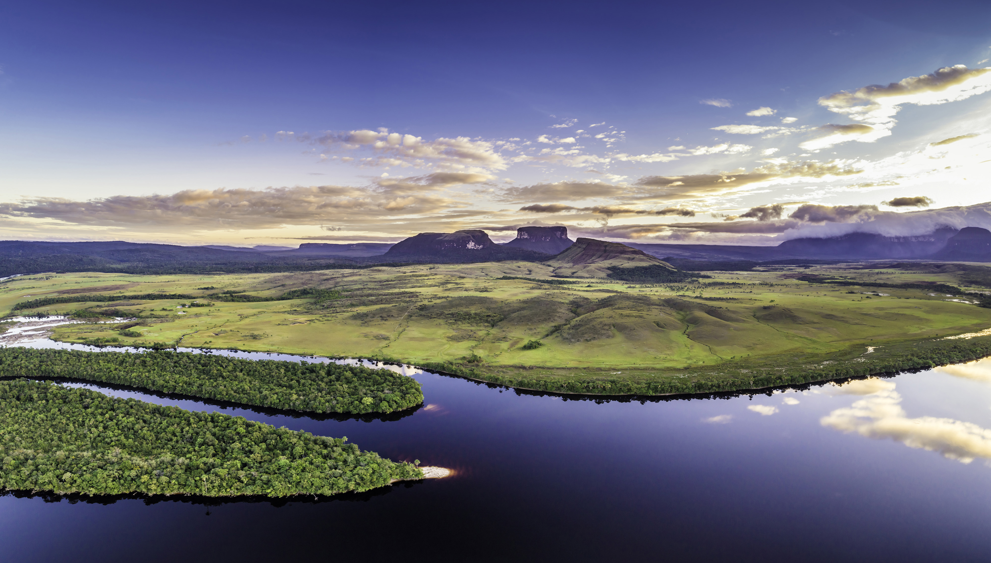 ����� 2 �� 34: Aerial  morning panoramic view of Canaima National Park tepuis and the Carrao river at Ucaima. At the background Kurun, Kusary and Kurawaik Tepuis. Canaima is a world known place for the beauty of nature and countless waterfalls. Canaima is visited for tourist all around the world during all year round. During rainy season navigation on the Churun river is possible to visit the Angel falls, the tallest waterfall in the world with 976 mt of water free fall.