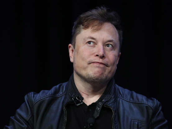 Elon Musk wearing a blue shirt