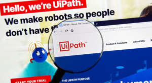 diagram, venn diagram: A magnifying glass zooms in on the website homepage of UiPath (PATH).