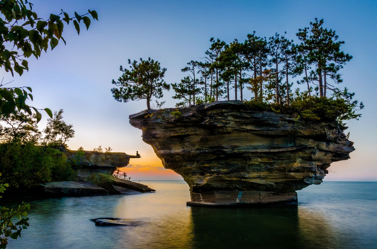 <p>This fascinating rock formation off the coast of Port Austin, Michigan, came to be after many years of waves wore down the stone. The land surrounding <a href="http://huroncountyparks.com/blog/about-turnip-rock-in-port-austin">Turnip Rock</a> is privately owned, however, so the only way to get up close and personal with the island is via water. Note that the area is especially shallow, so <a href="http://www.portaustinkayak.com/turnip-rock/">stepping out of a kayak</a> to take a beautiful photo like this one is doable.</p>