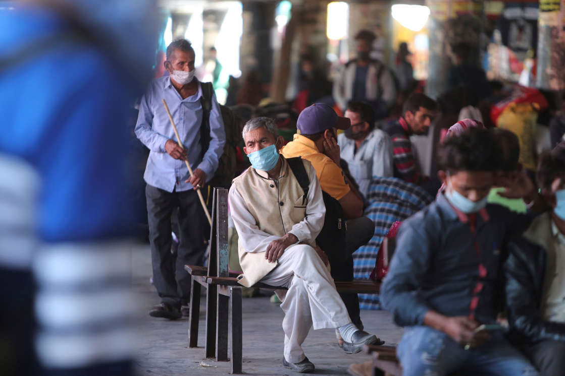Passengers wearing masks as a precaution against the coronavirus wait for transportation at a bus station in Jammu, India, Saturday, April 3, 2021. For several months, infections had receded, baffling experts, then since February, cases have climbed faster than before with a seven-day rolling average of 59,000. (AP Photo/Channi Anand)
