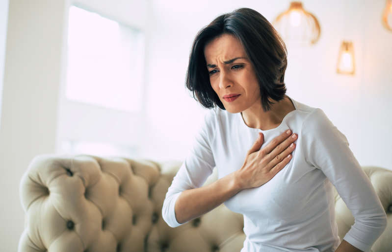 a woman looking at the camera: According to a 2018 study, “pill-induced esophagitis is a rare cause of acute chest pain. It is one of the potential side effects of commonly used drugs such as tetracycline, doxycycline, clindamycin, and nonsteroidal anti-inflammatories (NSAIDs). […] Risk factors for the development of drug-induced esophagitis include use of a small quantity of water when swallowing medication, lying down during or immediately after drug ingestion, and the presence of underlying esophageal disorders.” If you suffer from chest pain, contact your doctor immediately. They might suggest discontinuing the medication and look into underlying conditions.