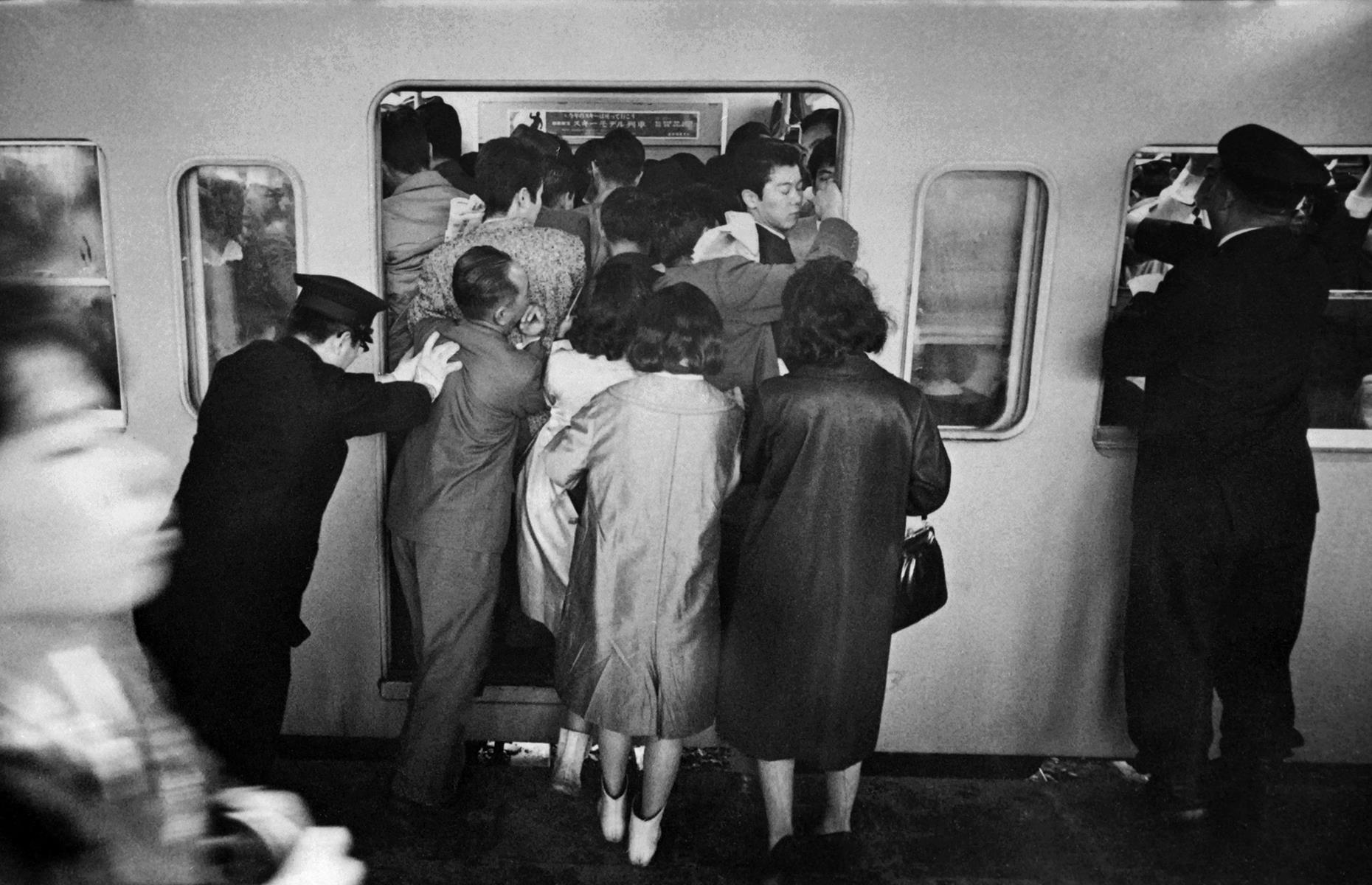 The stations are just as busy northeast of Osaka, in Japan's capital. In this photograph from the 1960s, station guards attempt to cram passengers onto a subway car before the doors close. Scenes like this are still common on Tokyo's sprawling subway network today – in fact, railway attendants nicknamed "pushers" exist with the job of pressing commuters onto heaving trains at rush hour.