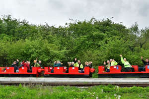 a group of people on a train track with trees in the background: The train at Lancashire Mining Museum