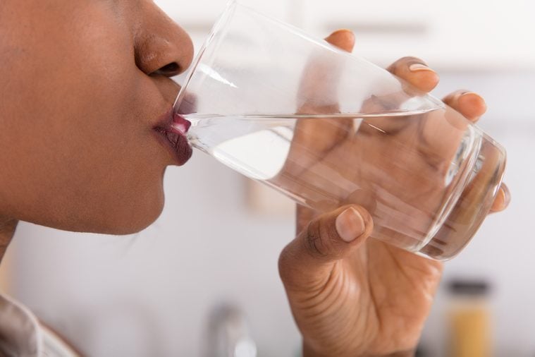 Close-up Of A Woman’s Hand Drinking Glass Of Water