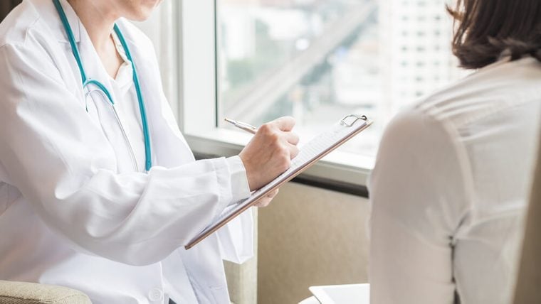 Doctor (gynecologist or psychiatrist) consulting and diagnostic examining woman patient’s health in medical clinic or hospital healthcare service center