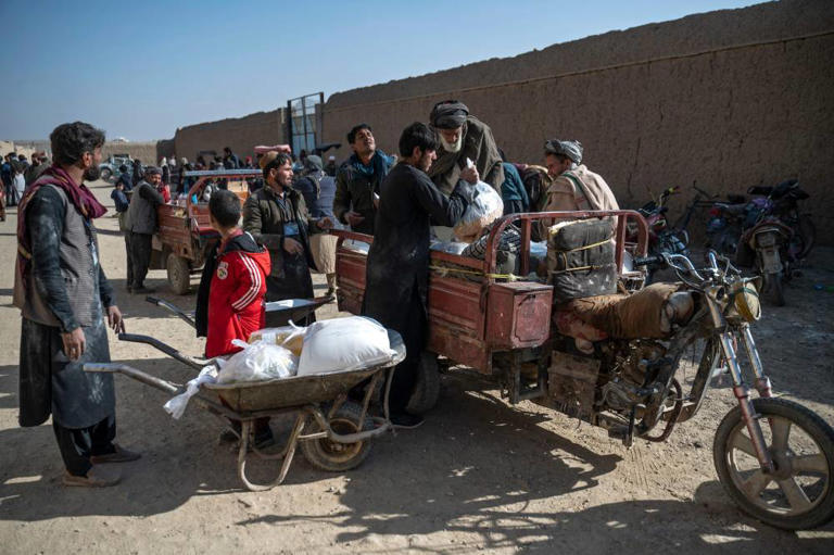 Afghan men load food packets on a vehicle distributed as humanitarian aid by the UN World Food Programme (WFP) at Nawabad Kako Sahib area in Baraki Barak district of Logar Province on January 7, 2024. - Photo by AFP