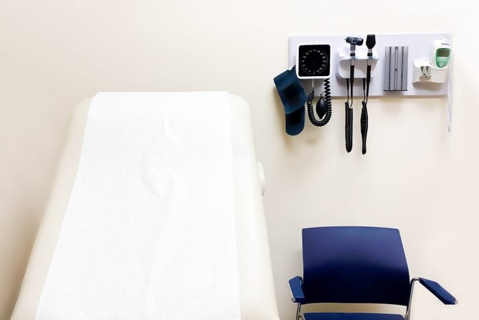 Access To Medical Care: Wall Mounted Medical Diagnostic Equipment Beside Standard Patient Examination Chair