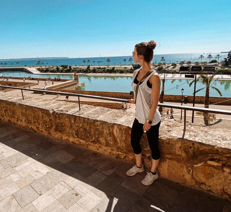 A woman looking over a balcony into the ocean