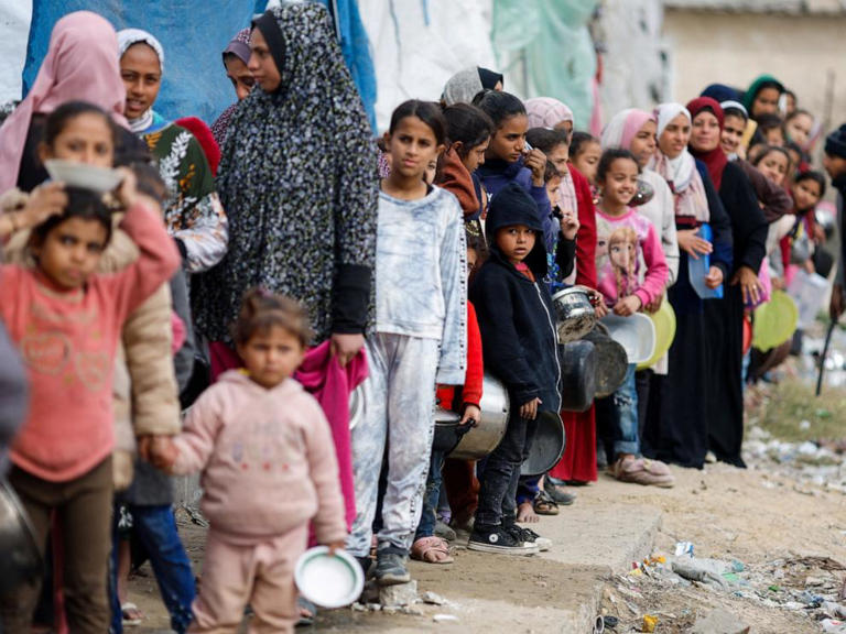 Palestinians stand in a line as they wait to receive food amid shortages of food supplies, Jan. 17, 2024, in Rafah in the southern Gaza Strip.