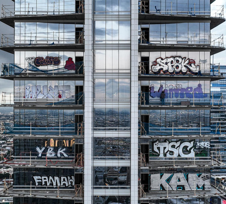 Taggers seen in action at graffiti-covered L.A. skyscraper. Across ...