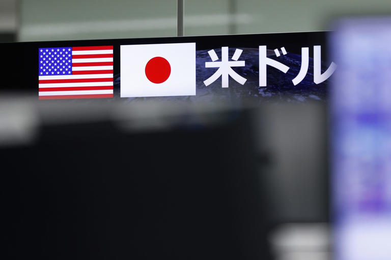 Images of the US and Japanese flags displayed on a monitor in the trading room at foreign exchange brokerage Gaitame.Com Co. in Tokyo, Japan, on Thursday, Oct. 5, 2023. Japan likely refrained from intervening in the currency market to prop up the yen earlier this week, according to an analysis of central bank accounts.