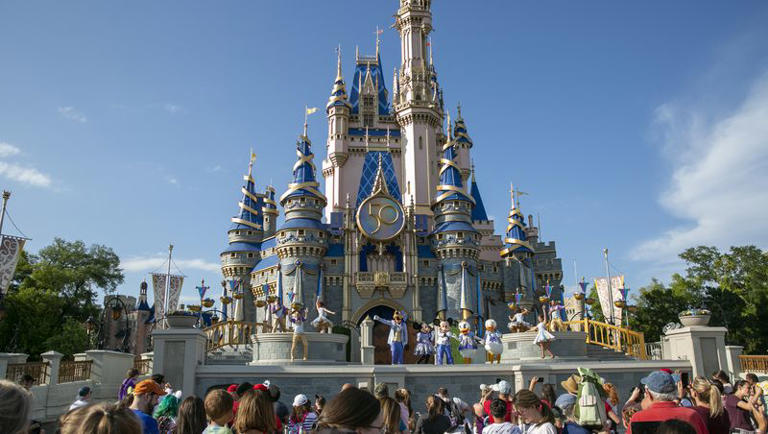 Performers dressed as Disney characters entertain visitors at Cinderella Castle at Walt Disney World Resort in Florida.