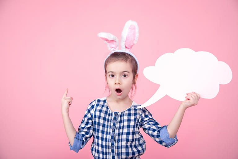 Little girl in bunny ears holding a speech bubble
