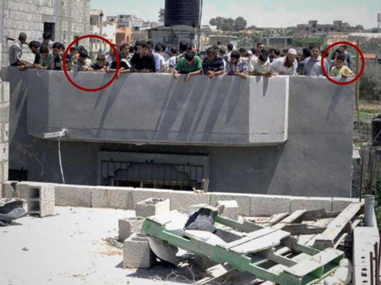 The IDF says this photo shows Gazan civilians, including children (circled), acting as voluntary human shields by assembling on the roof of a building that had received an IDF warning in 2014. (Israel Defense Forces)