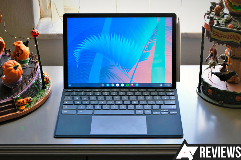 An HP Chromebook x2 11 sitting on a table in front of a window with amusement part decorations on the table next to it
