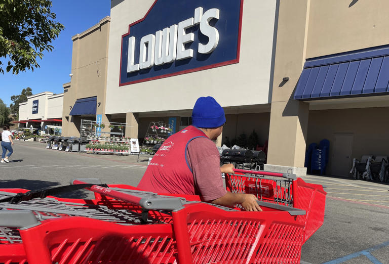 A worker moves shopping carts at a Lowe's store on November 21, 2023, in Pacoima, California.