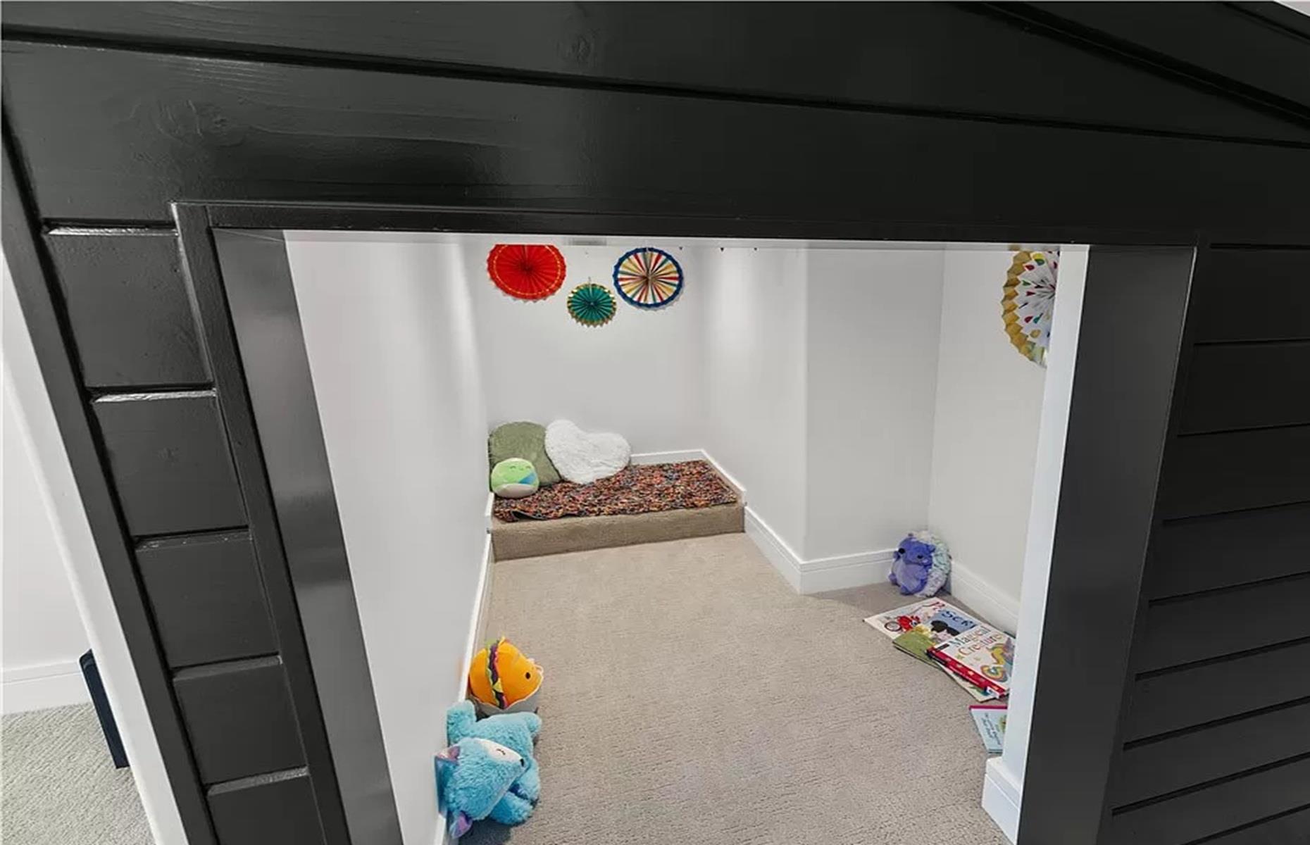 <p>Head through the door and you'll find a secretive storage room, complete with the ultimate kid's play den. The space boasts a cute faux house, where the owners' children no doubt spent a lot of time playing their favorite games.</p>