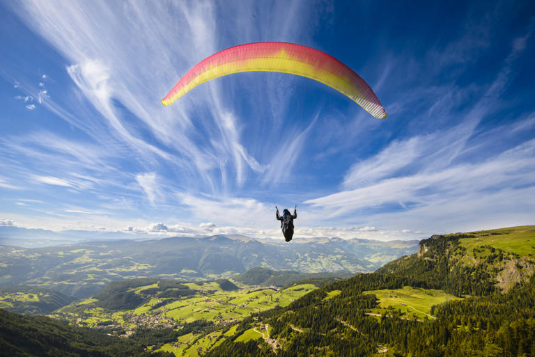 Paraglider soaring over the mountains