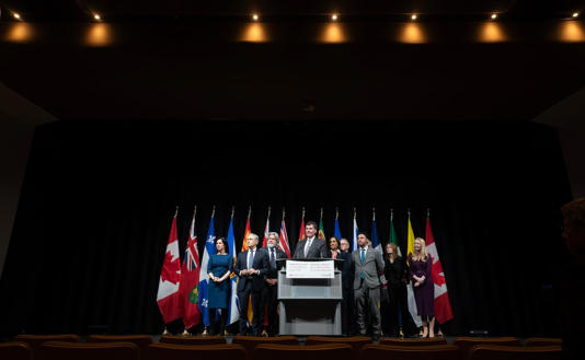 Cabinet members, police and municipal leaders surround Minister of Public Safety Dominic LeBlanc as he speaks during a news conference at the National Summit on Combatting Auto Theft, in Ottawa, Thursday, Feb. 8, 2024. (Adrian Wyld/Canadian Press)