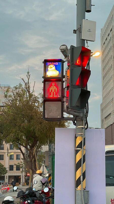 民眾發現，高雄海邊路的紅綠燈行人號誌上的圖案，也變成黃色小鴨圖案了，上面還有「I’M BACK」字樣，模樣超萌。   圖：翻攝自Wecare高雄臉書