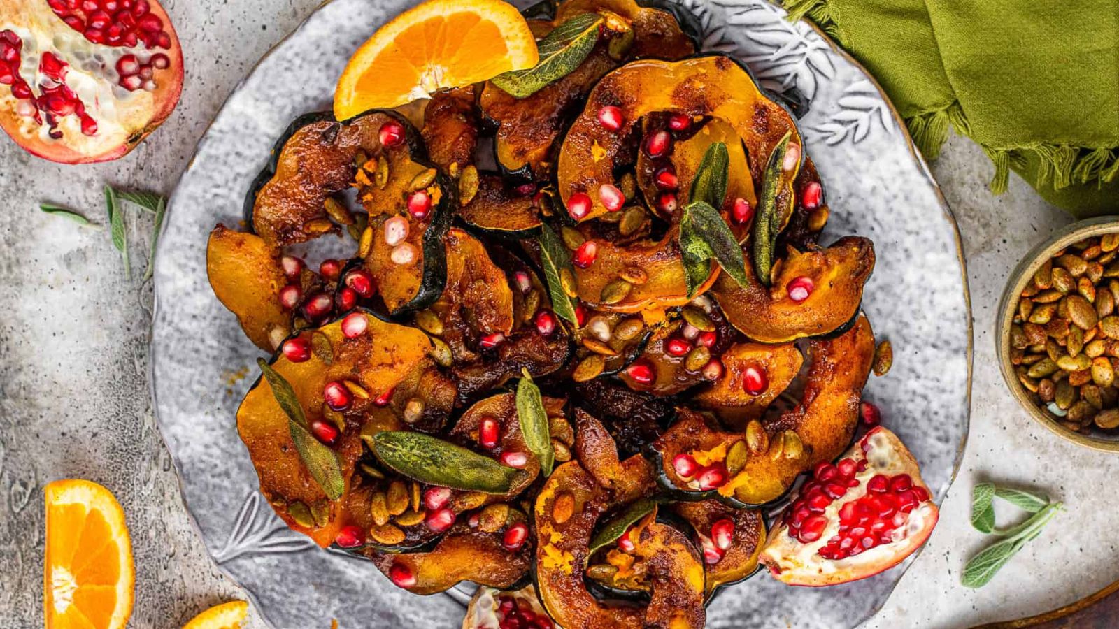<p>This Roasted Acorn Squash is a beautiful and delicious side dish. Sliced acorn squash is oven roasted in a sweet and spicy buttery sauce, then topped with toasted pumpkin seeds, pomegranate arils, and orange zest for a holiday table showstopper!</p>