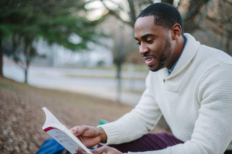 Here are some of the best business books. Pictured: a man outside reading a book.