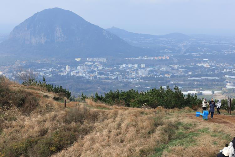 Visitors enjoy panoramic views around the grassy plateau of Gunsan Oreum in Seogwipo, Jeju Island, Wednesday. Yonhap