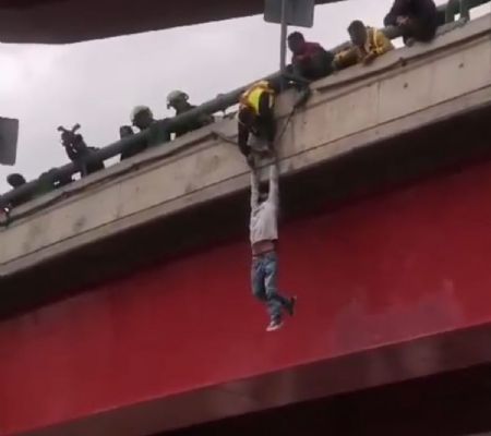un hombre intenta lanzarse de un puente, lo disuaden y cae en el intento de rescatarlo