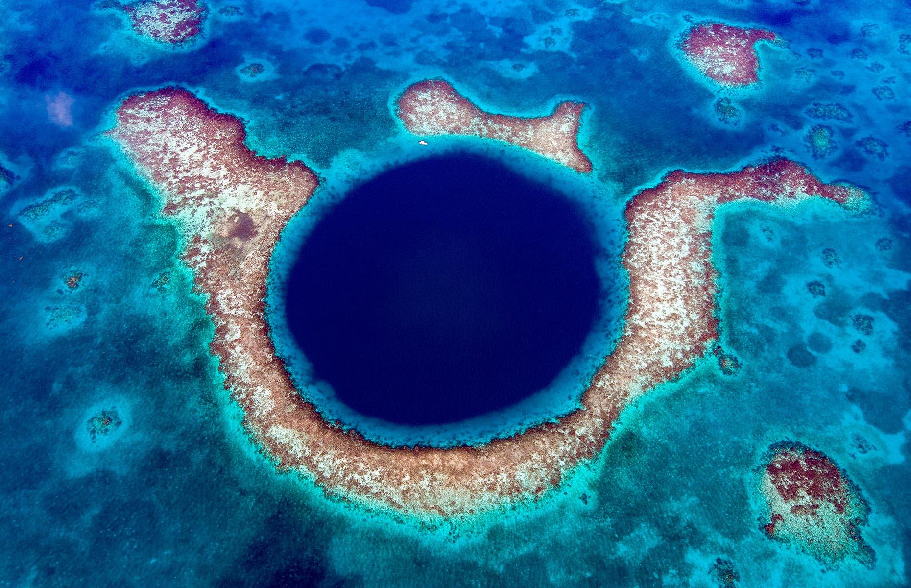 <p>By far Belize's best-known natural wonder, the Blue Hole has spent decades on the front covers of guide books, and remains one of the country's main draws. A vast sinkhole stamped like an inkblot on the ocean, it's more than 1,000 feet across and resides in the middle of Lighthouse Reef, roughly 43 miles from the mainland. It's almost <em>too</em> big and <em>too</em> blue – the colorful fish and vibrant corals tend to stop at the perimeter, and from down on the water it's hard to get any sense of scale. We recommend taking a tourist flight above the feature, which you can do in a helicopter or light aircraft.</p>