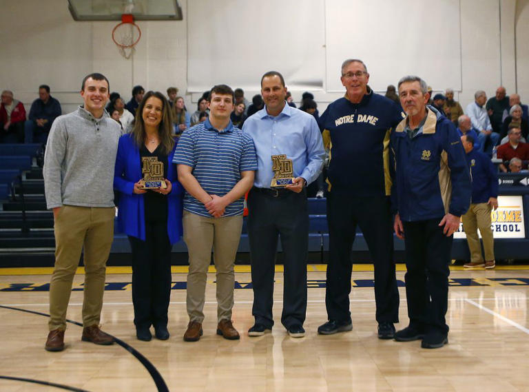 Tom Keppel, third from right, and the family of the late John McGuire, left, stand on the court after the induction of the latest additions to the Notre Dame Athletic Hall of Fame on Jan. 26, 2024.