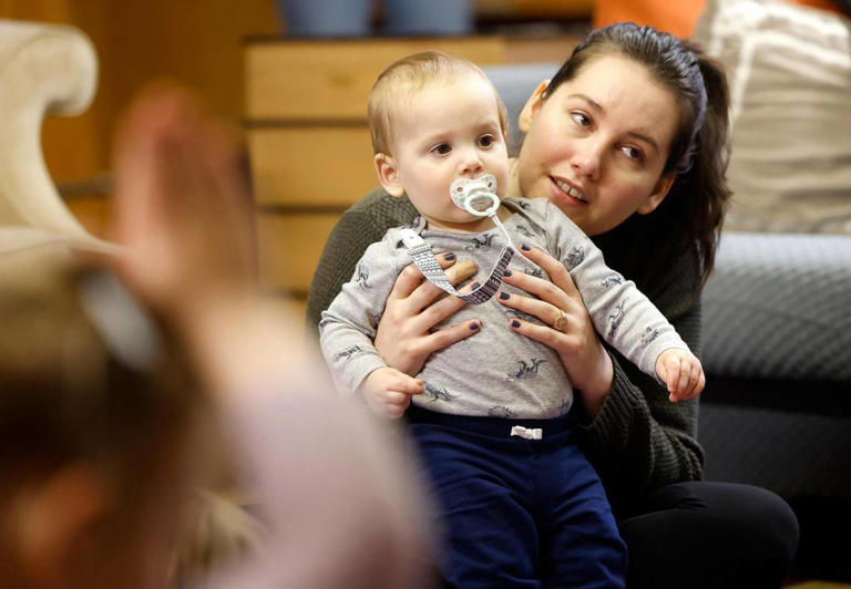 Miranda Tiblier holds her son, Griffin, 1, as they participate in a yoga class for children at the Fairmount Community Library on Tuesday, January 23, 2024. Tiblier said that Griffin enjoys observing the world around him and thought he would enjoy the class.