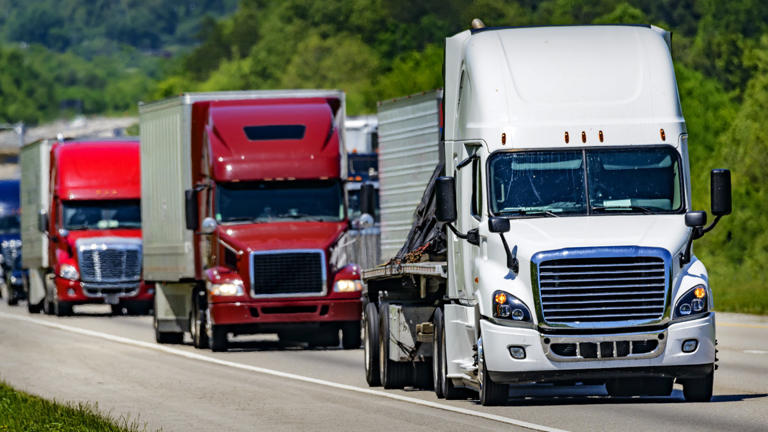 A number of tractor trailers are one the road. Full Truck Alliance Lead