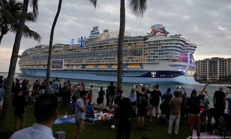 People film and wave from South Pointe Park, as Icon of the Seas, the world's largest cruise ship, sails out of Port Miami on its first public cruise, Jan. 27, 2024. Photo by AP