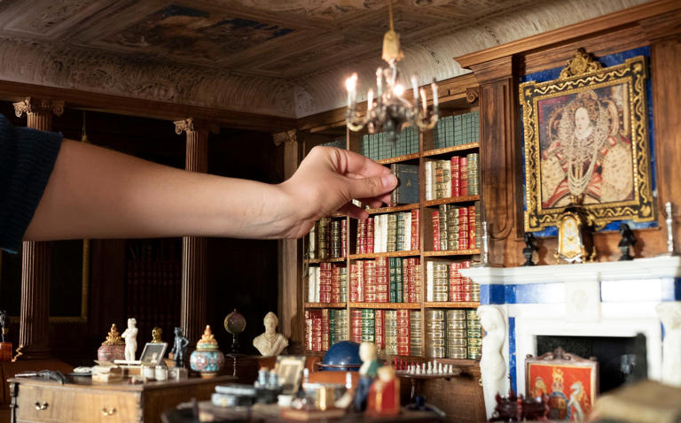 Queen refreshes royal dolls house's tiny library with modern authors to ...