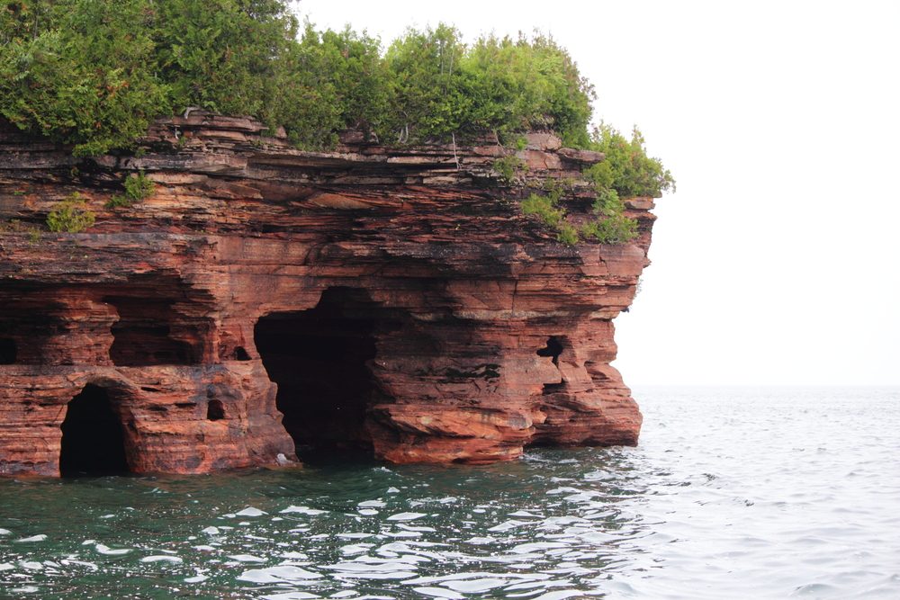 <p>The archipelago of 21 islands you'll see from the shores of Lake Superior is much more than meet the eye. Because while you can take a ferry to Madeline Island for a day of hiking, the real treasure lies below the surface in the interconnected passageways of sandstone caves whittled out underneath the islands. In the summer, kayak through the cavernous rooms or, if it's winter, simply trek across the frozen lake and marvel at the massive icicles hanging from the ceilings. Find out <a class="SWhtmlLink" href="https://www.rd.com/list/best-weekend-getaways-in-every-state/">the best weekend getaway in every state</a>.</p>