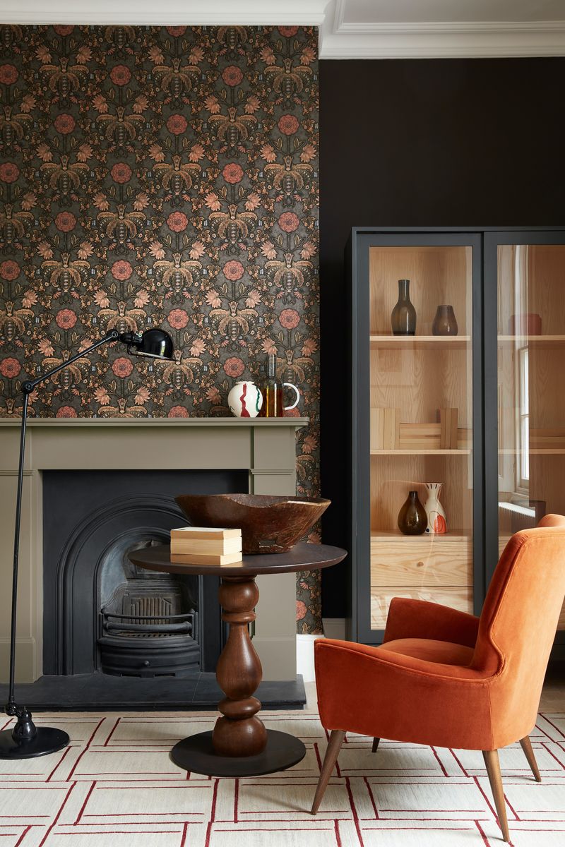 <p>Don't be afraid to go dark in a living room – you can tie the scheme together with bold, punchy accents, like this burnt orange armchair. Wooden furniture grounds the scheme.</p><p><em>Pictured: London Wallpapers, New Bond Street - Hide, <a href="https://www.littlegreene.com/new-bond-street-hide">Little Greene</a></em></p>
