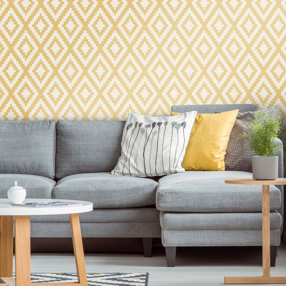<p>A simple, geometric design that is bold but not overpowering will give a lift to any living room. This combination uses the softer end of the palette with a chalky grey linen upholstered sofa and muted yellow walls.</p><p><em>Top Tip: </em>Choose cushions that complement the colour scheme but also add pattern and texture.</p><p><em>Pictured: Geometric Mustard, <a href="https://www.ilovewallpaper.co.uk/wallpaper-c1/fabric-geometric-wallpaper-mustard-p7254/s7390">I Love Wallpaper</a></em></p>