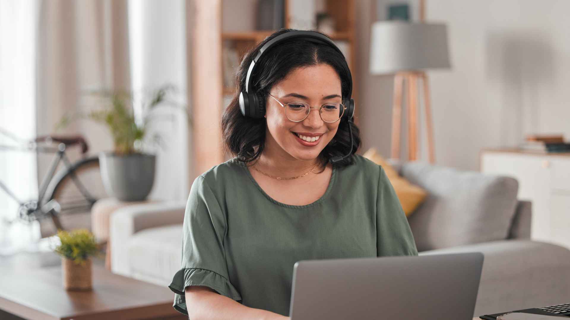Happy, remote work and woman with a laptop for call center communication and consultation. Smile, virtual assistant and a customer service agent typing on a computer from a house for telemarketing
