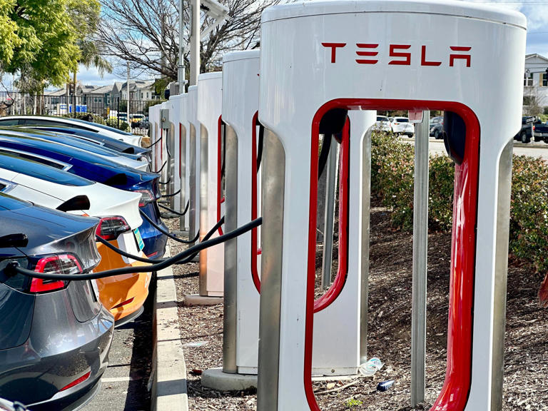 Electric vehicle owners connect to a Tesla charging station at the Target in Simi Valley on Monday, Feb. 5, 2024.