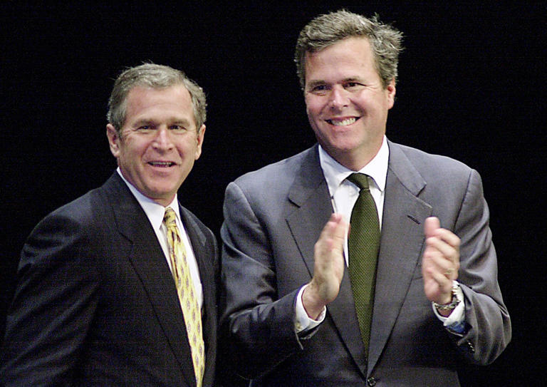 President George Bush is joined onstage by brother, Gov. Jeb Bush, during an appearance Monday at the Marina Civic Center in Panama City. Bush visited airmen at Tyndall Air Force Base to talk about quality-of-life issues before pitching his tax-cut plan to a crowd of 2,500. March 12, 2001. Daily News/DEVON RAVINE. 13p2bush