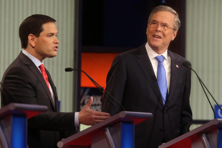 Republican presidential hopeful Jeb Bush (right) reacts as he listens to Mraco Rubio (left) during the Republican debate at the Iowa Events Center in Des Moines, IA on January 28, 2015.