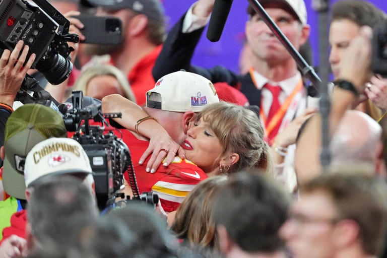 Chiefs tight end Travis Kelce hugs girlfriend Taylor Swift on the field after winning Super Bowl 58.
