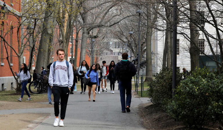Students and pedestrians walk through the Yard at Harvard University in Cambridge, Mass., March 10, 2020.