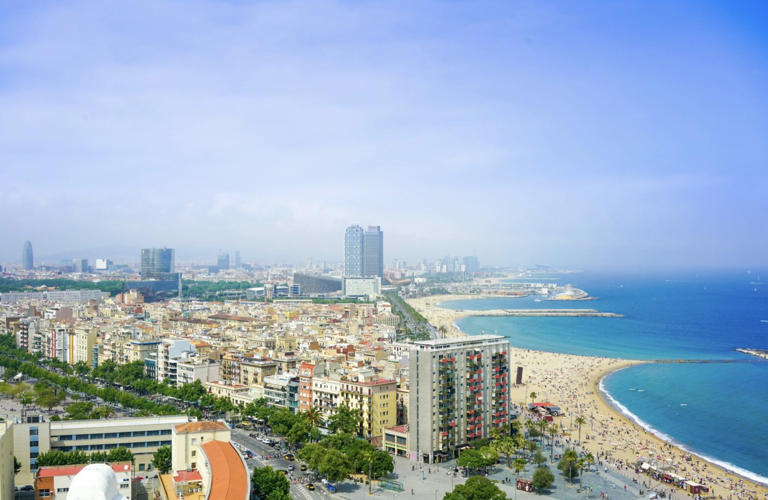 The cruise port of Barcelona is quite popular due to its safety, amenities and convenience. Pictured: the cityscape of Barcelona with views of the beach and blue skies