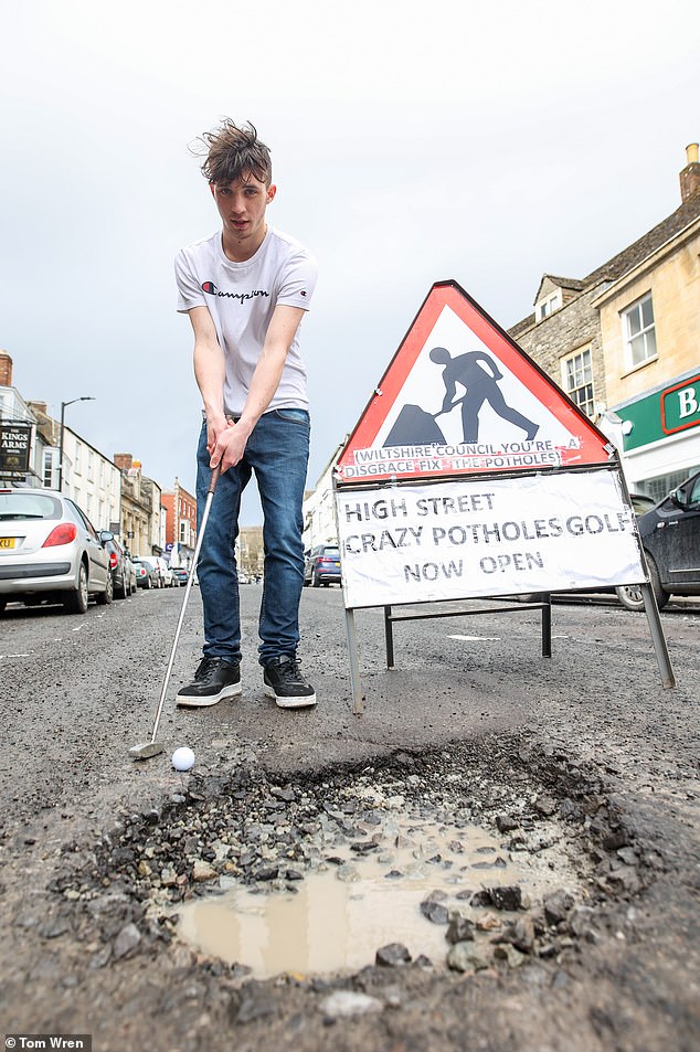 amazon, they've driven him potty! teenager, 19, stages bizarre pothole protest by 'going fishing' in the craters with a photo of his local mp taped over his face - after previously turning road into a crazy golf course