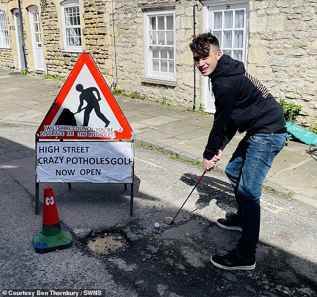 amazon, they've driven him potty! teenager, 19, stages bizarre pothole protest by 'going fishing' in the craters with a photo of his local mp taped over his face - after previously turning road into a crazy golf course